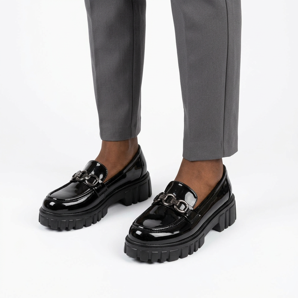Adult woman wearing black glossy linked-detail chunky loafers