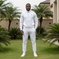 Nigerian male model wearing all-white quilted zip-up tracksuit set