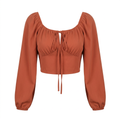 Rust-orange cropped tie-front blouse with long puff sleeves on an invisible mannequin
