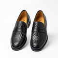 Pair of black embossed-vamp saddle loafers on white