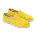 A pair of yellow suede loafers with cream soles on a white background