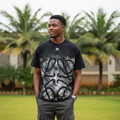 Nigerian male model wearing men's black abstract face graphic print shirt