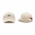 Cream off-white dad cap with navy blue 1987 number embroidery ghost mannequin front and side view