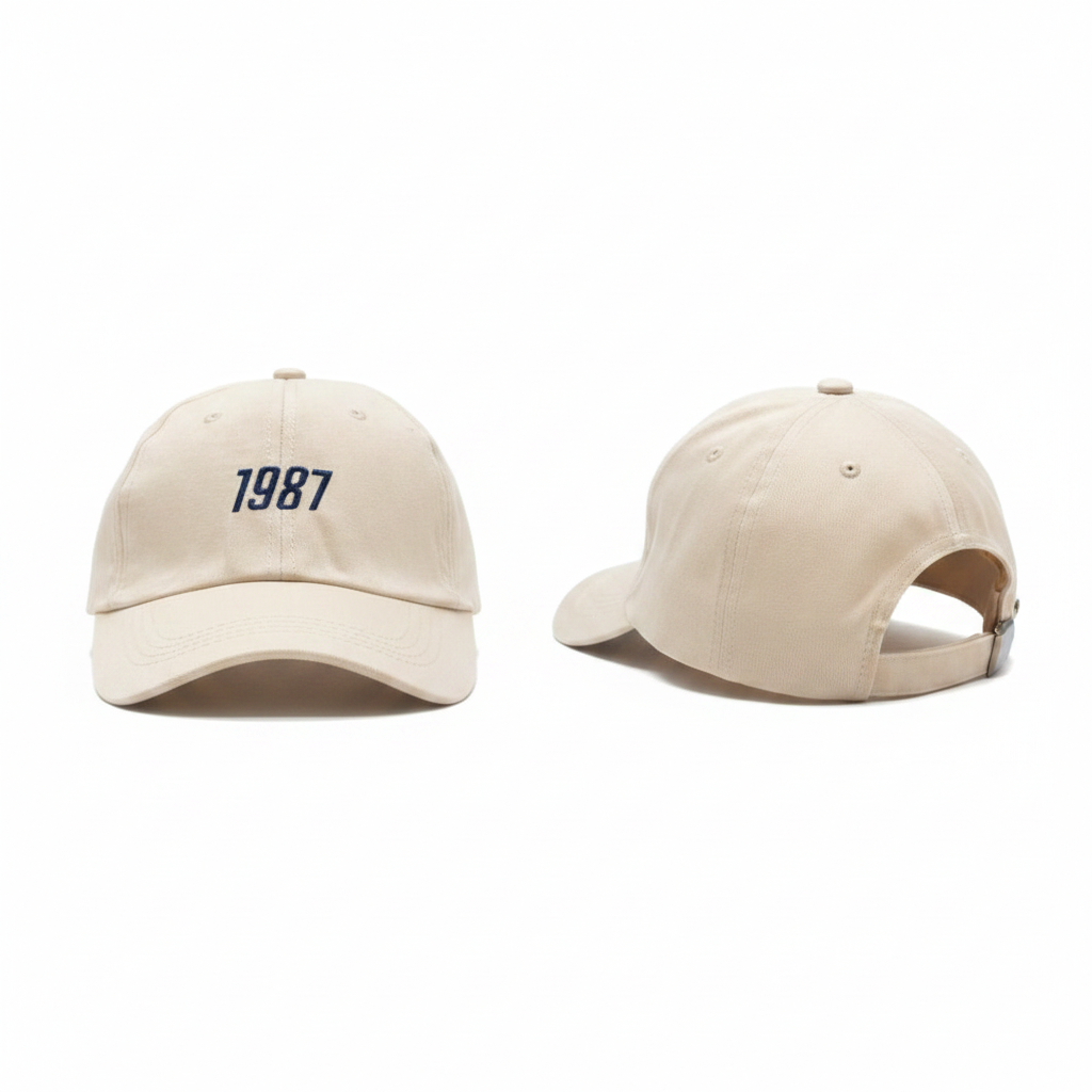 Cream off-white dad cap with navy blue 1987 number embroidery ghost mannequin front and side view