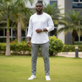 Nigerian male model wearing grey geometric checked trousers in outdoor setting