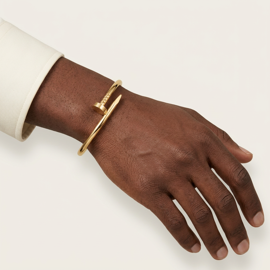Yellow-gold-tone nail-style bracelet worn on a male model’s wrist