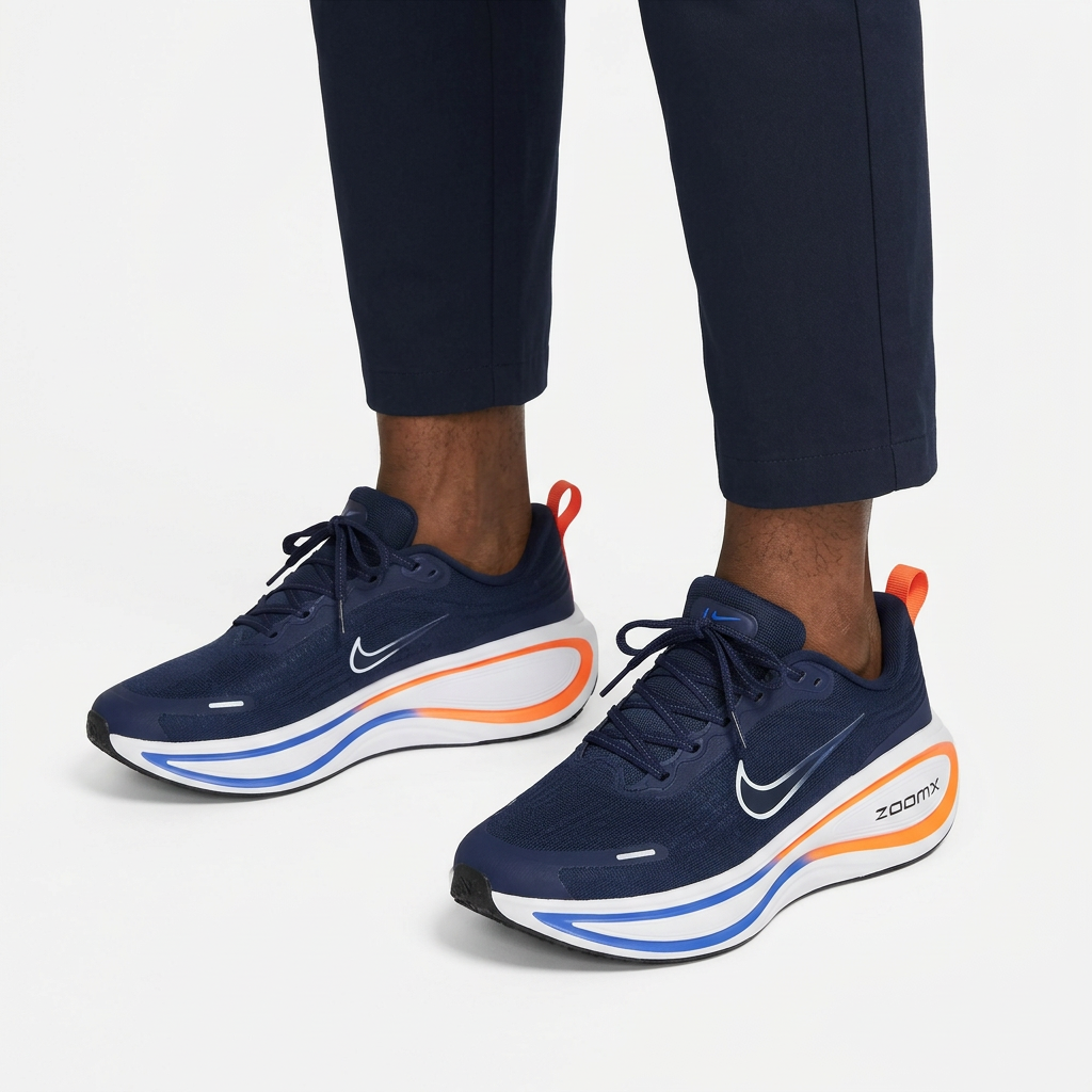 Navy and orange lace-up sneakers worn on both feet with cropped trousers