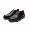Pair of burgundy leather medallion toe oxford brogues on a white background