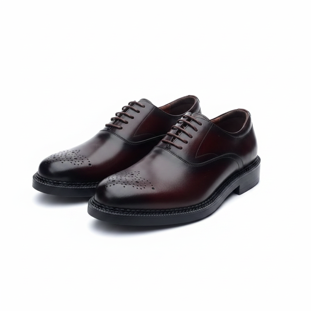 Pair of burgundy leather medallion toe oxford brogues on a white background