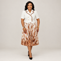 Black Nigerian model wearing a white and tan gown with brown lapel trim and pleated geometric skirt