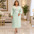 Woman wearing a mint green pleated midi dress with lace detail