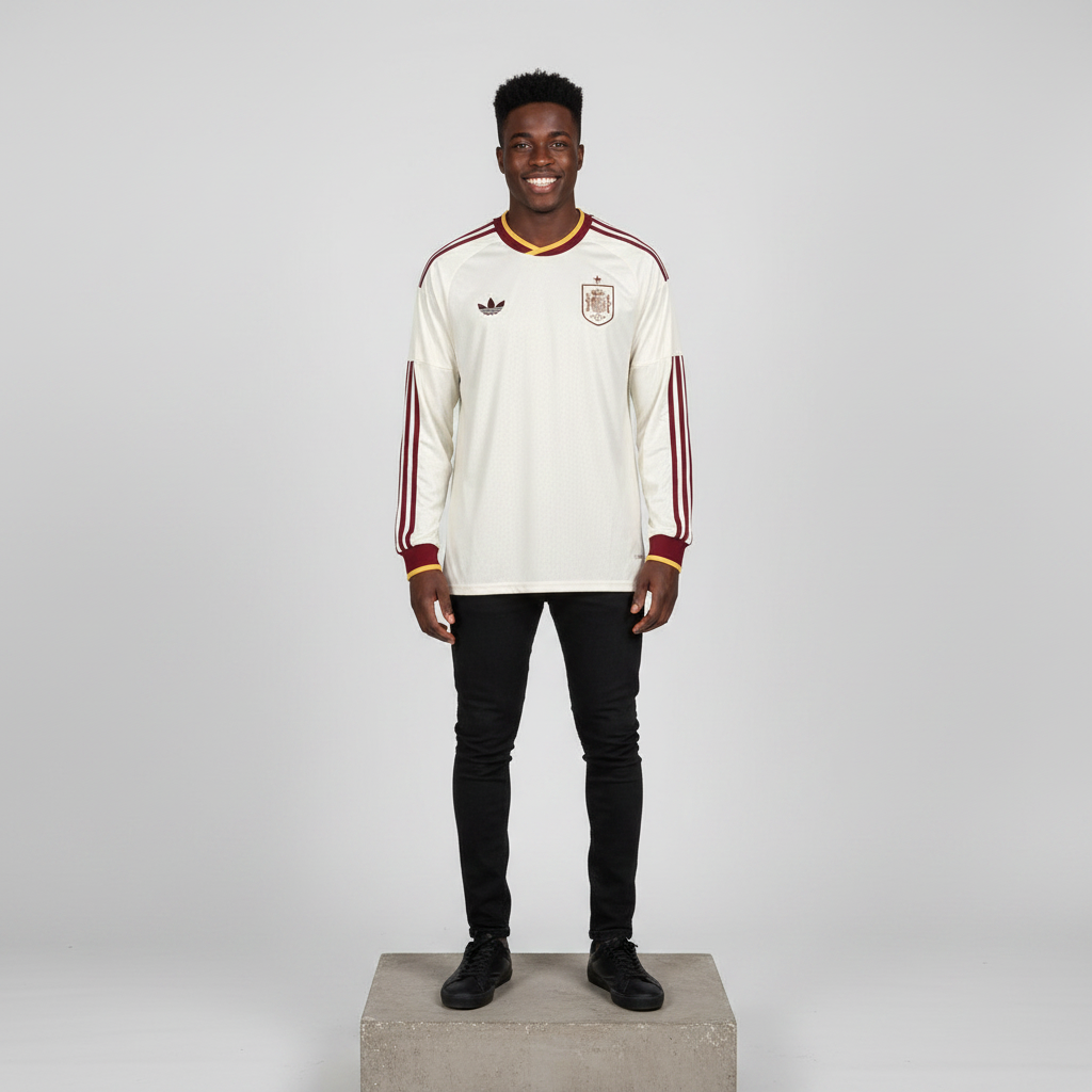 Nigerian male model wearing cream maroon gold long sleeve football jersey on concrete plinth