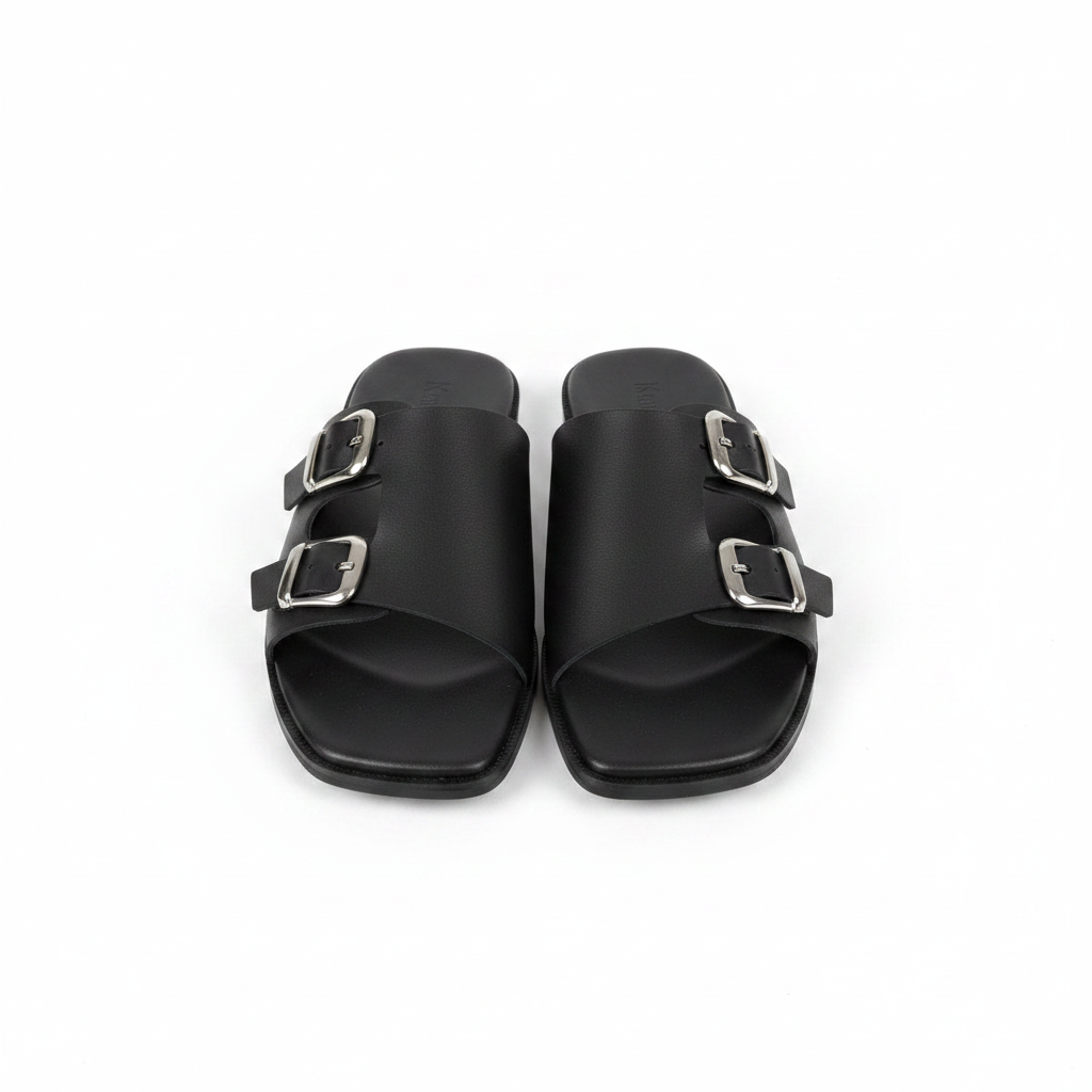 Pair of black leather double buckle flat slide slippers on white background