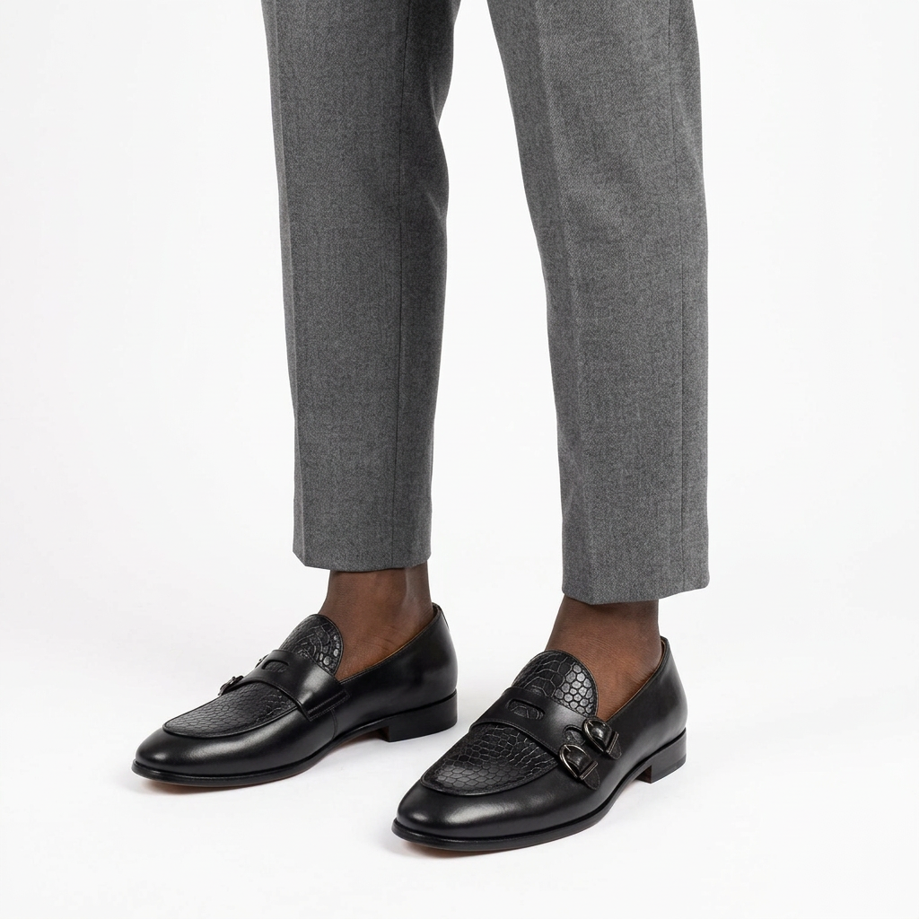Black crocodile-effect double-buckle loafers worn on both feet