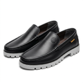 Pair of black embossed-emblem loafers with grey lug soles on white