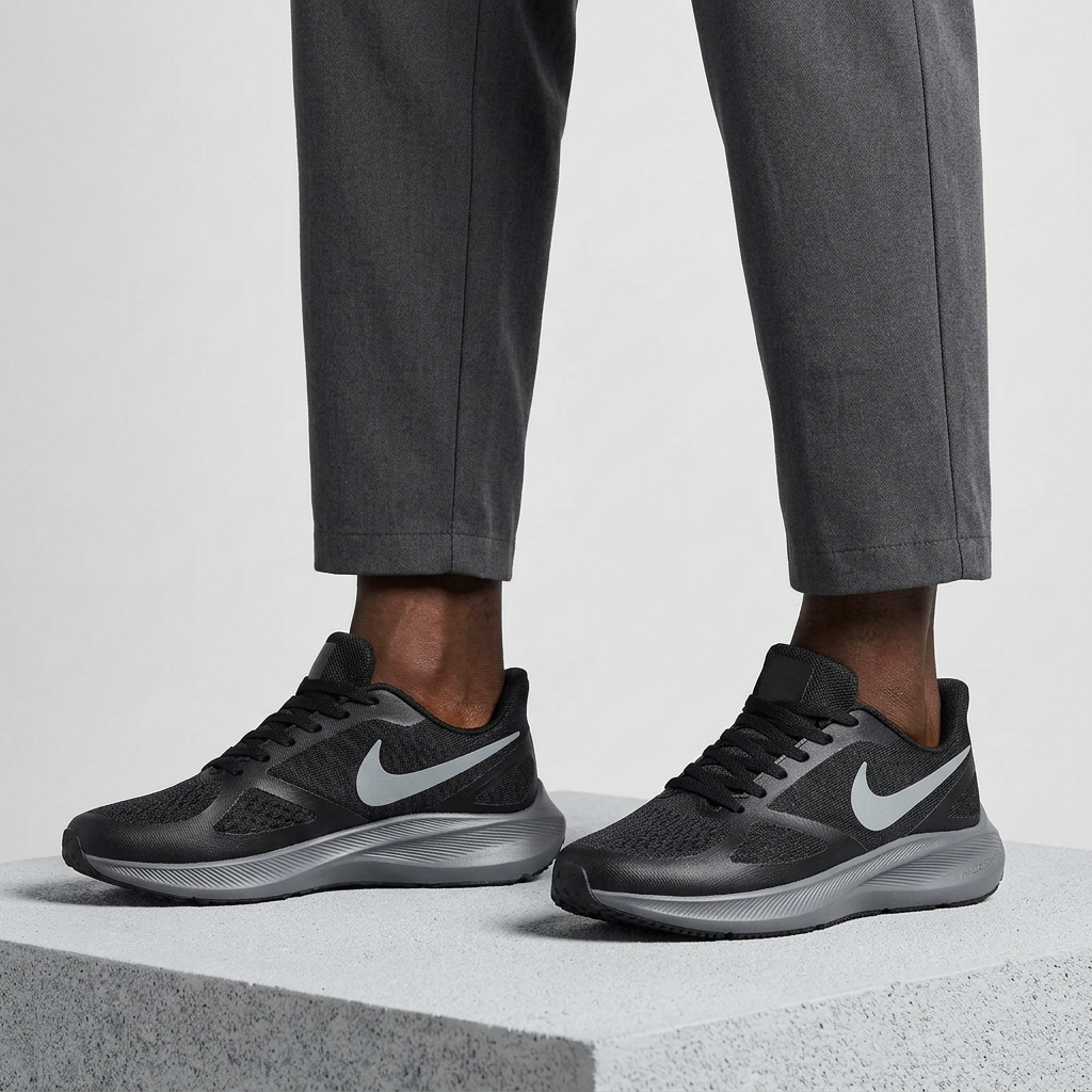Leg-focused model wearing black mesh sneakers with grey side accents