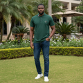 Nigerian male model wearing men's forest green polo shirt with tricolour striped collar, garden setting