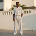 Male model wearing white black pinstripe alo polo and trouser two-piece set