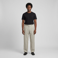 Full-body male model wearing light beige pleated trousers
