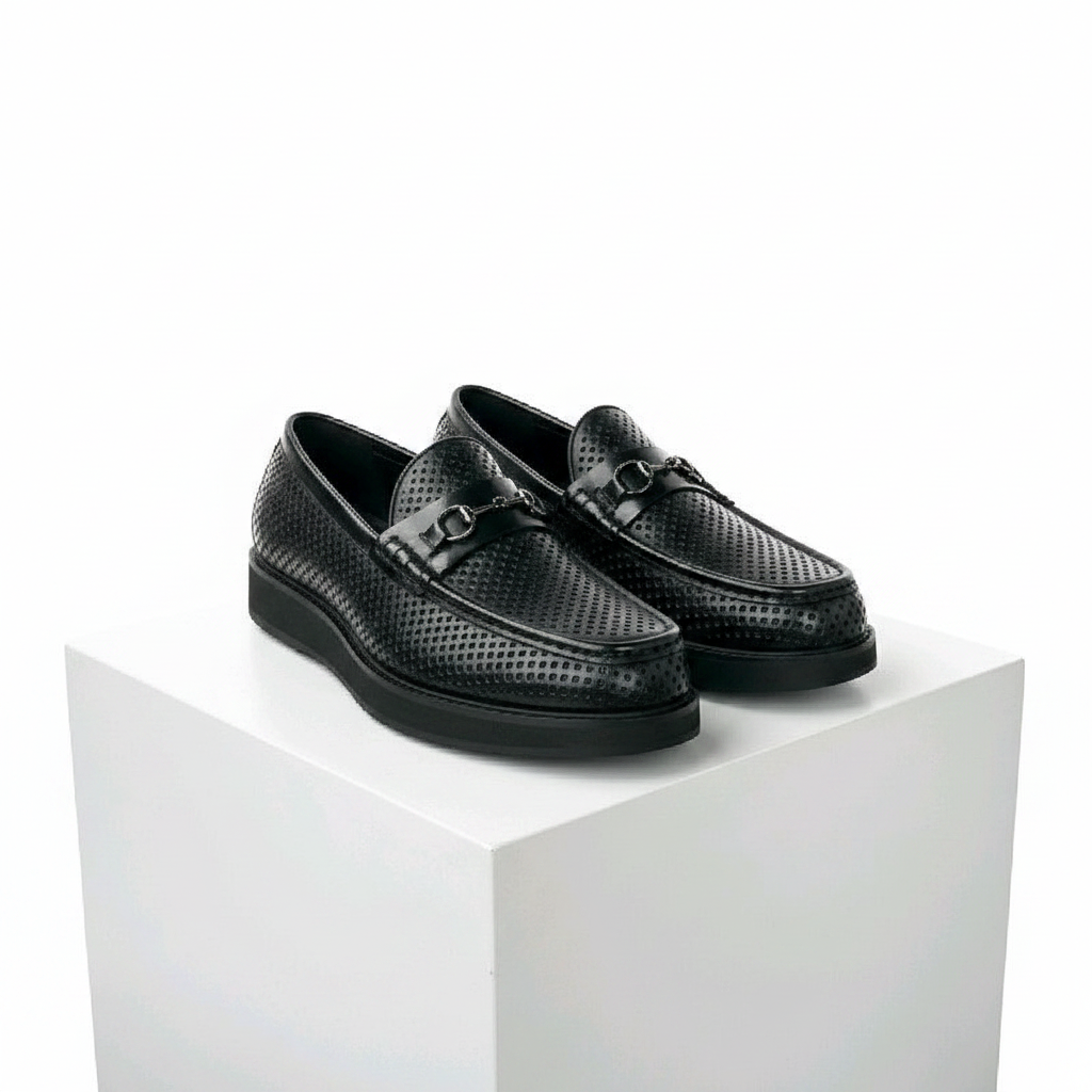 Men's black perforated leather horsebit loafer shoes pair on white platform