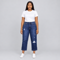 Black woman wearing dark blue distressed jeans, front view