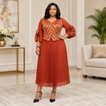 Adult Black woman wearing a terracotta gold patterned pleated dress