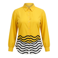 Yellow collared blouse with black-and-white wave-patterned hem on an invisible mannequin against white