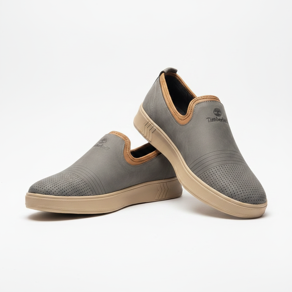 Men's slate grey nubuck leather slip-on sneakers with tan trim and chevron sole pair product shot