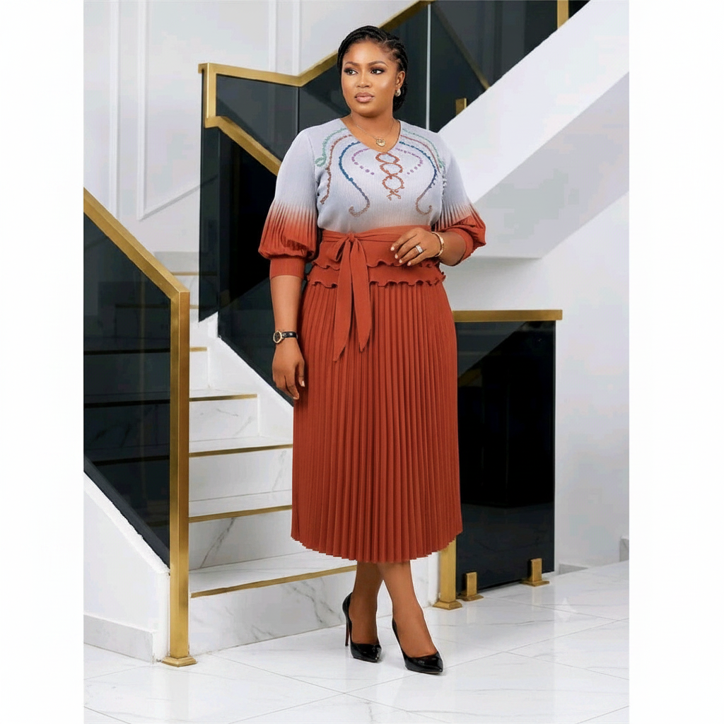 Nigerian woman wearing grey and rust ombre embroidered top and pleated midi skirt set
