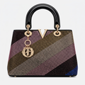 Multicolour diagonal studded black handbag on a plain white background
