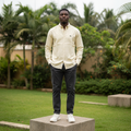 Nigerian male model wearing men's pale lemon yellow long-sleeve button-down casual shirt, garden setting
