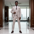 Young Nigerian male model wearing beige 3-piece suit with dark brown paisley tie and pocket square