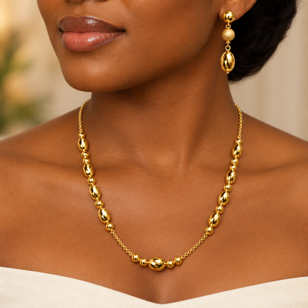 Woman wearing polished gold bead necklace and drop earrings