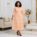 Black Nigerian woman wearing peach tiered pleated occasion dress