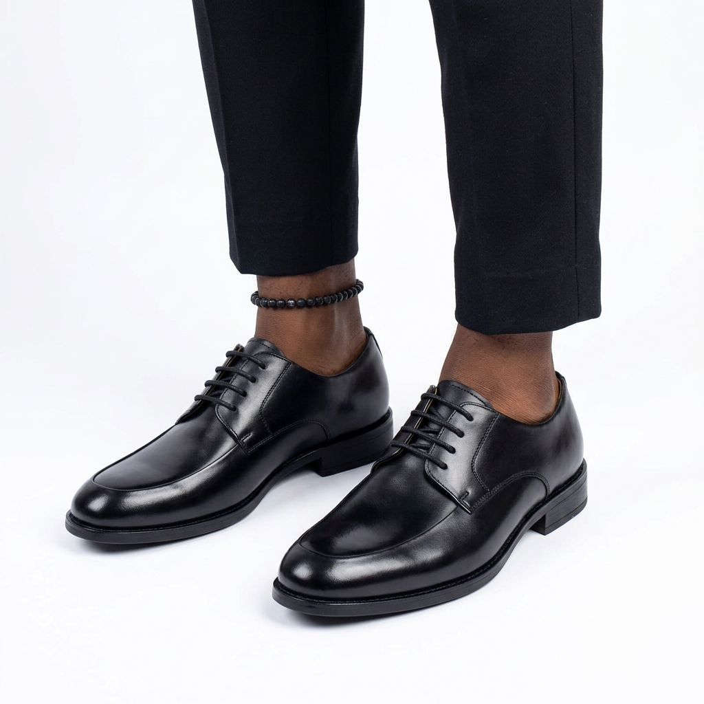 Both black apron-toe lace-up shoes worn with tailored trousers on white