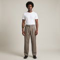 Full-body male model wearing taupe belted pleated trousers