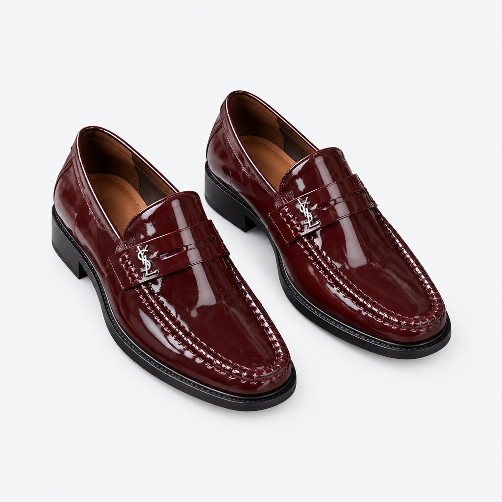 Oxblood men's patent loafers with polished metal detail shown as a complete pair