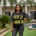 Women's black neon text graphic tee with denim sleeve trim - female model shot