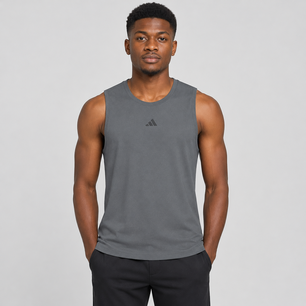 Man wearing slate-grey tank against plain studio background