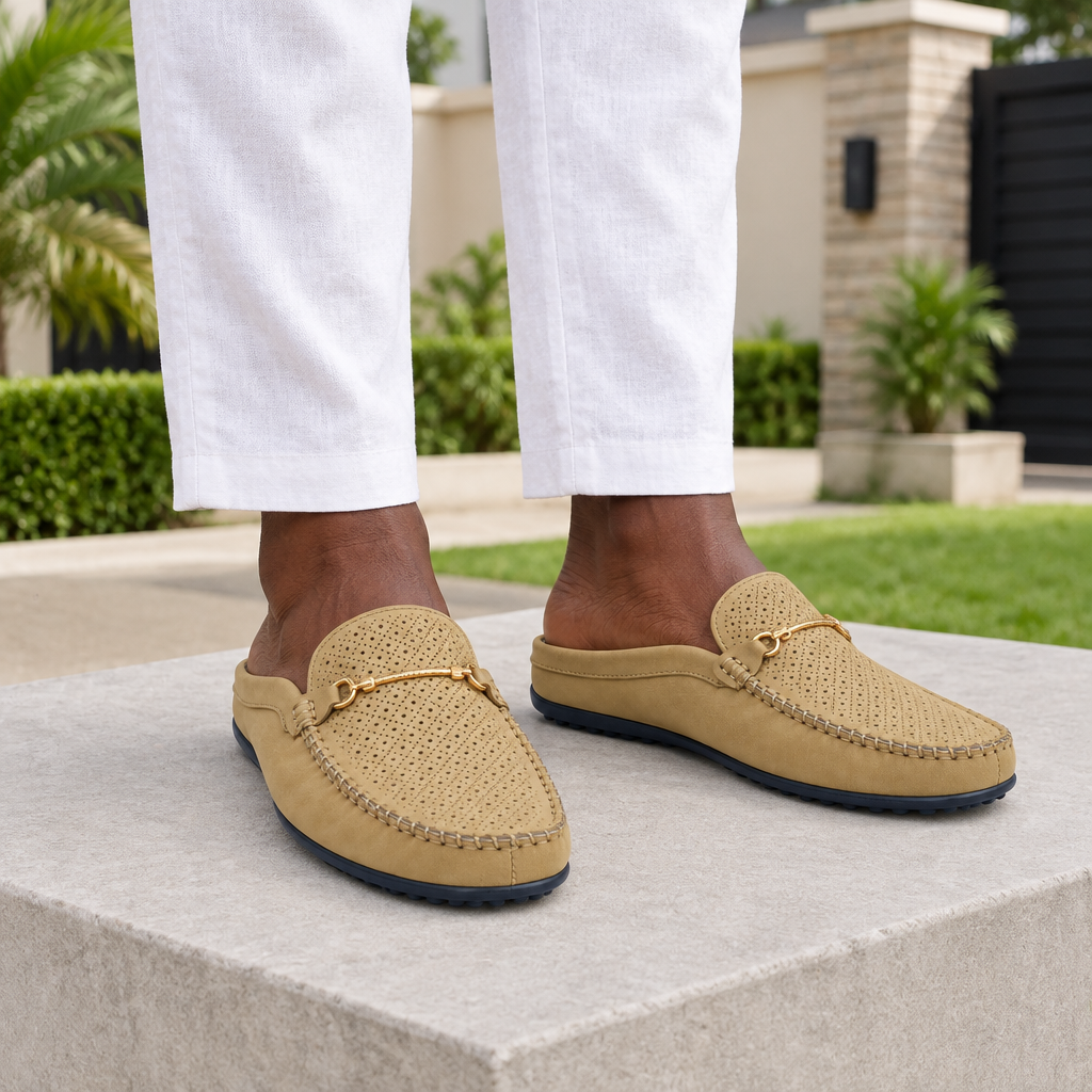 Man wearing tan perforated horsebit mule slippers with white linen trousers