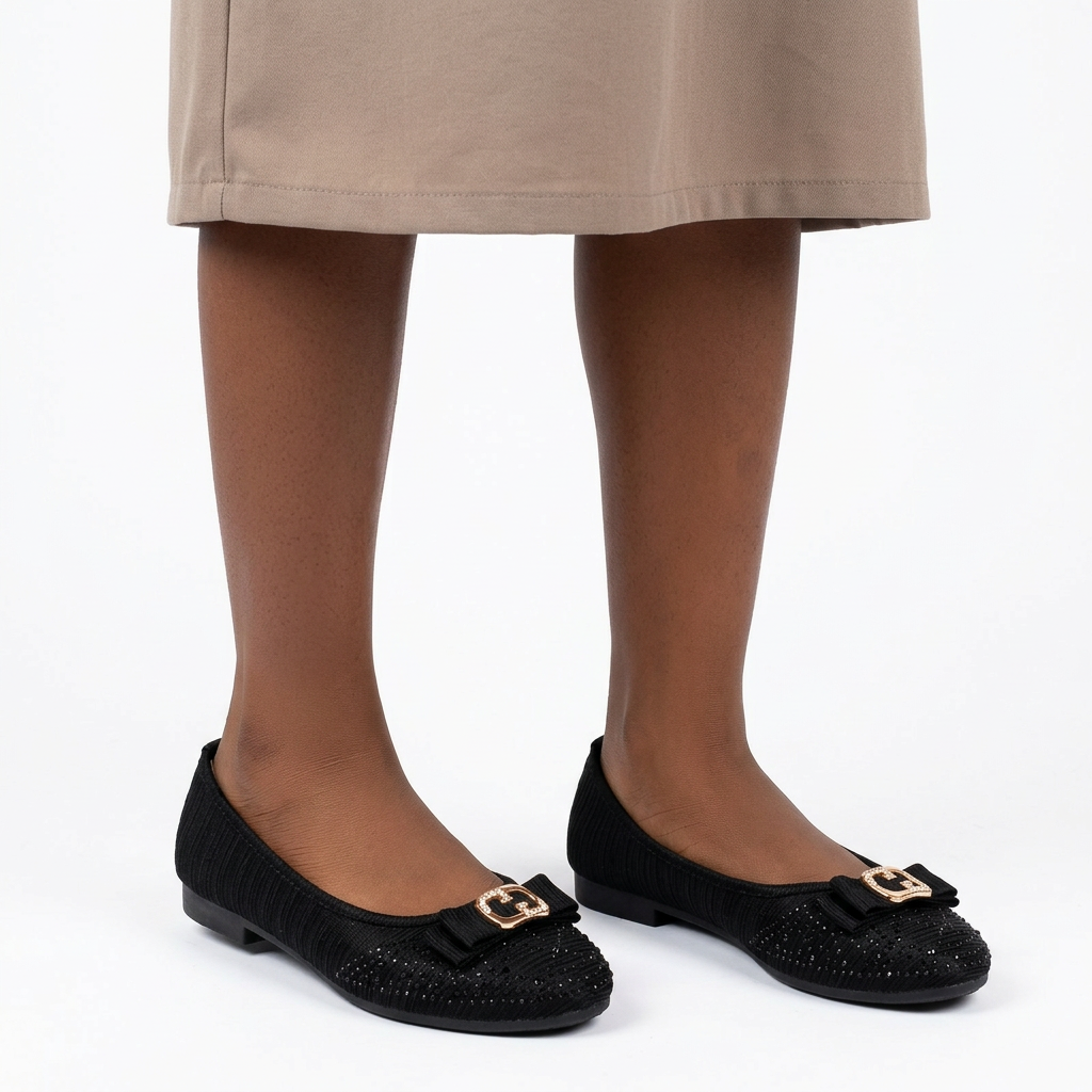 Girl wearing black textured gold-buckle ballet flats