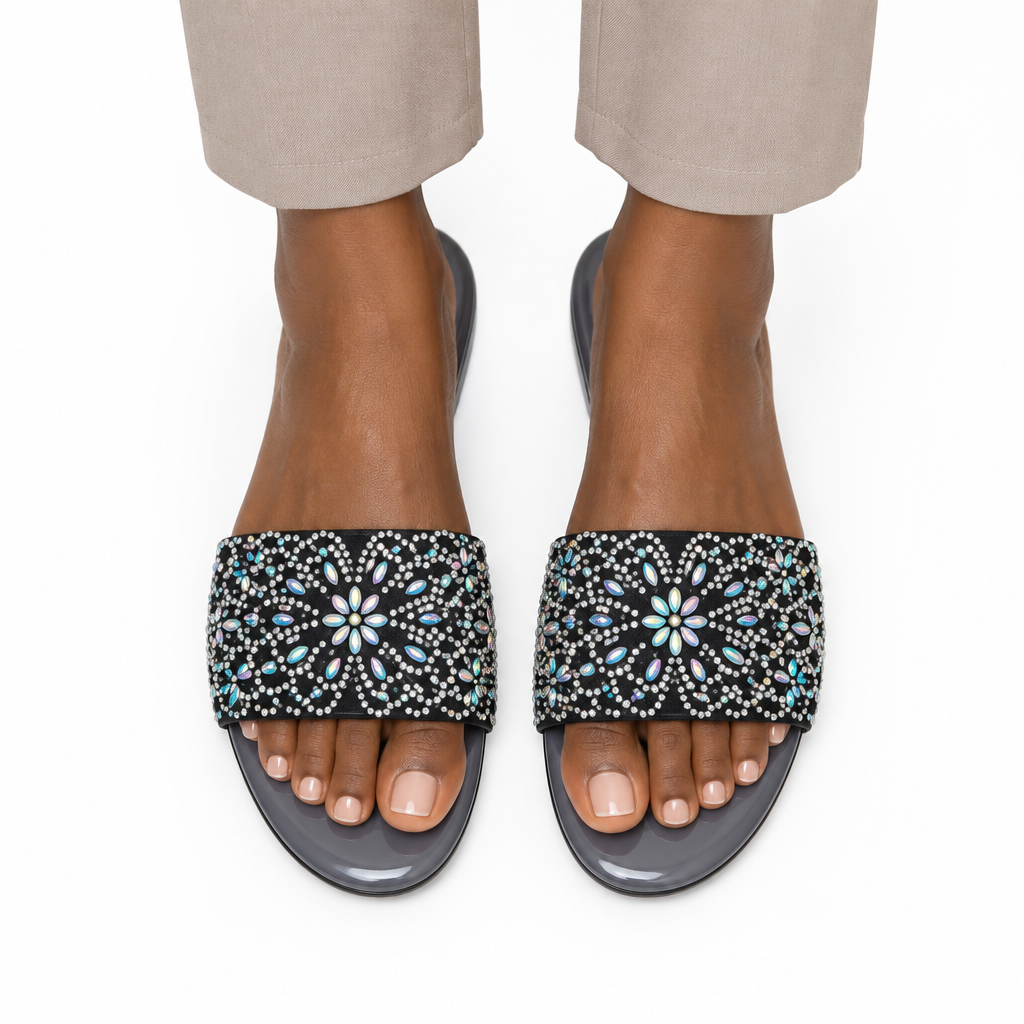 Adult woman wearing black floral-stone flat slide sandals