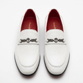 Straight-on white textured loafers with dark geometric hardware and red lining
