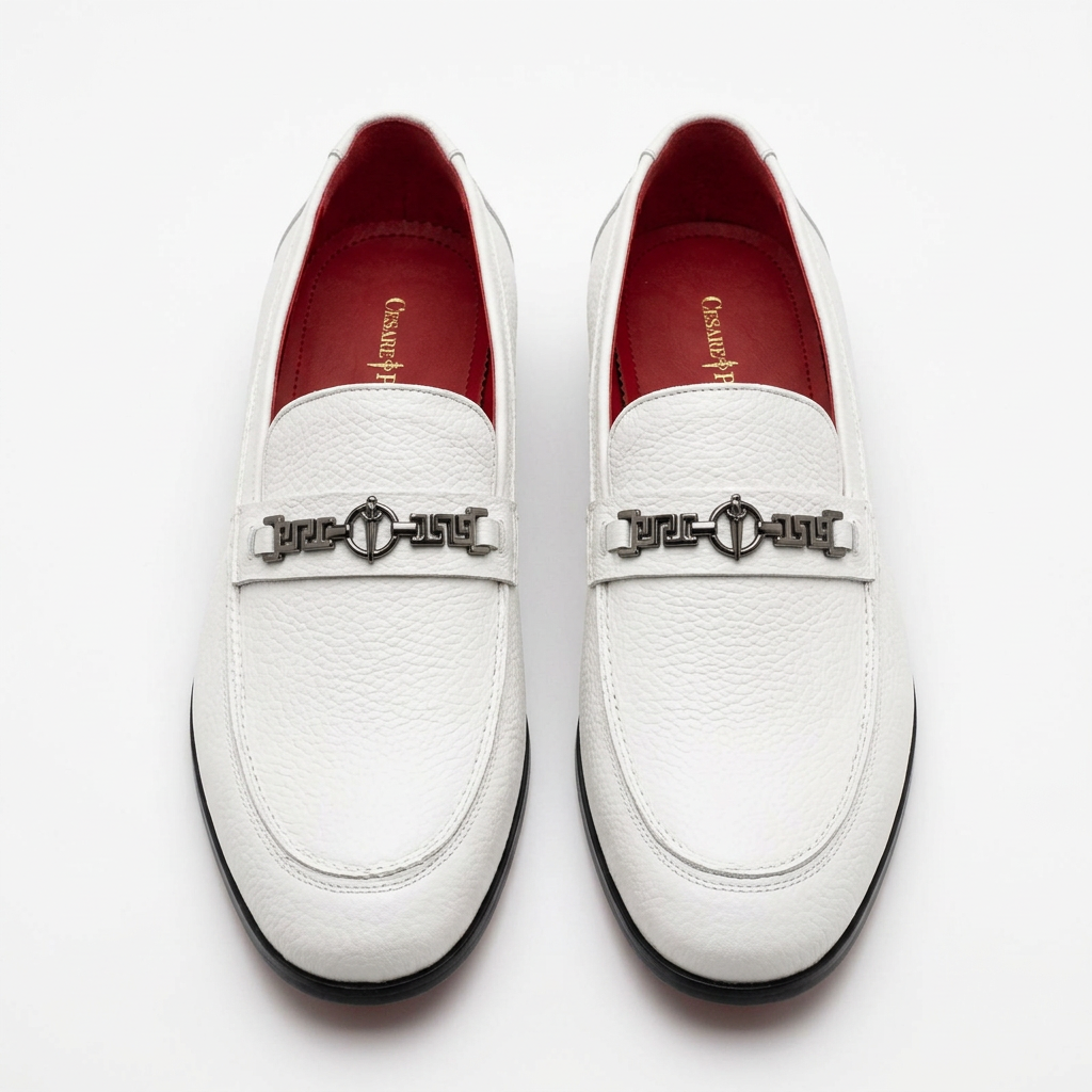 Straight-on white textured loafers with dark geometric hardware and red lining