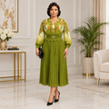 Adult Black woman wearing an olive green floral pleated dress