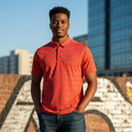 Young Nigerian male model wearing a red striped performance polo shirt