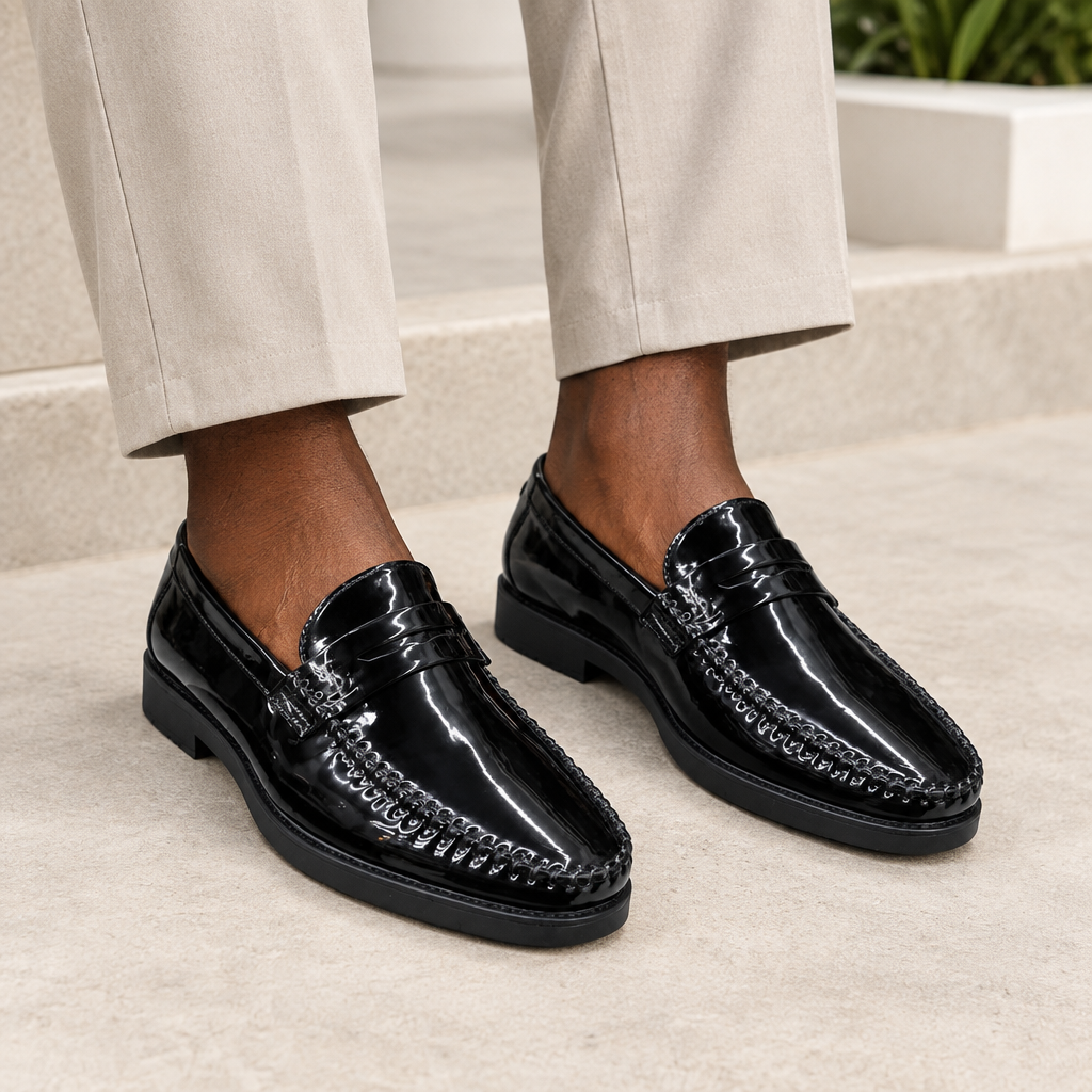 Black model wearing black men's patent moc-toe loafers