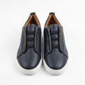 Pair of men's navy textured lace-up sneakers with tan lining and white soles
