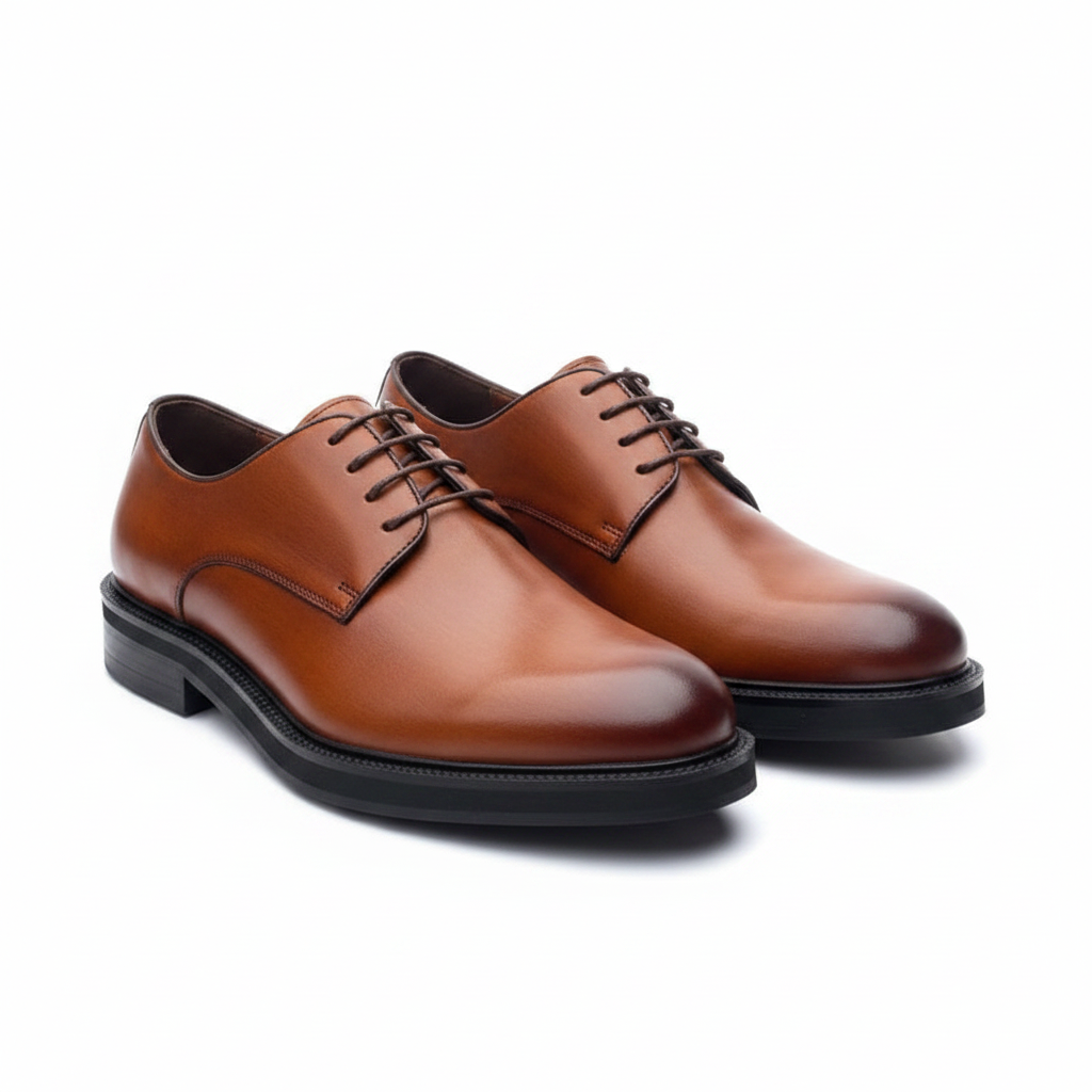 Pair of tan cognac leather plain toe derby shoes on a white background