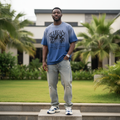 Nigerian male model wearing men's blue acid-wash graphic short-sleeve tee full body streetwear shot